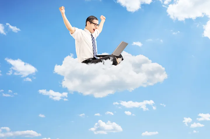 Man på moln med en laptop i sitt knä